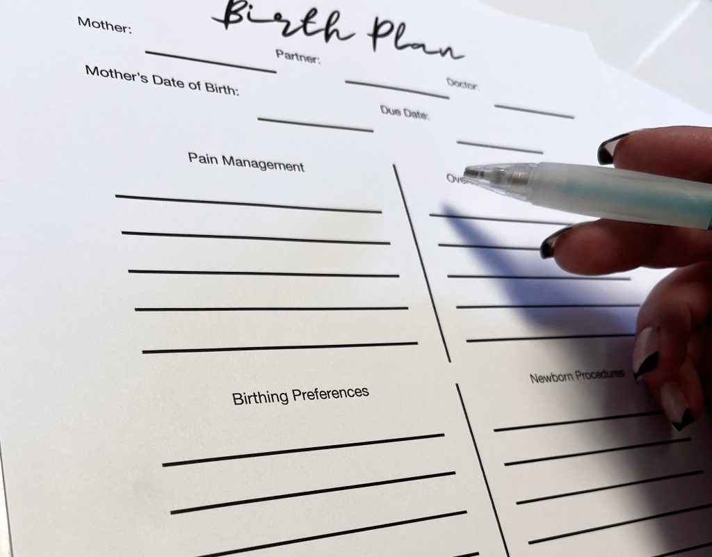 holding a pen so it looks like I'm writing on my birth plan