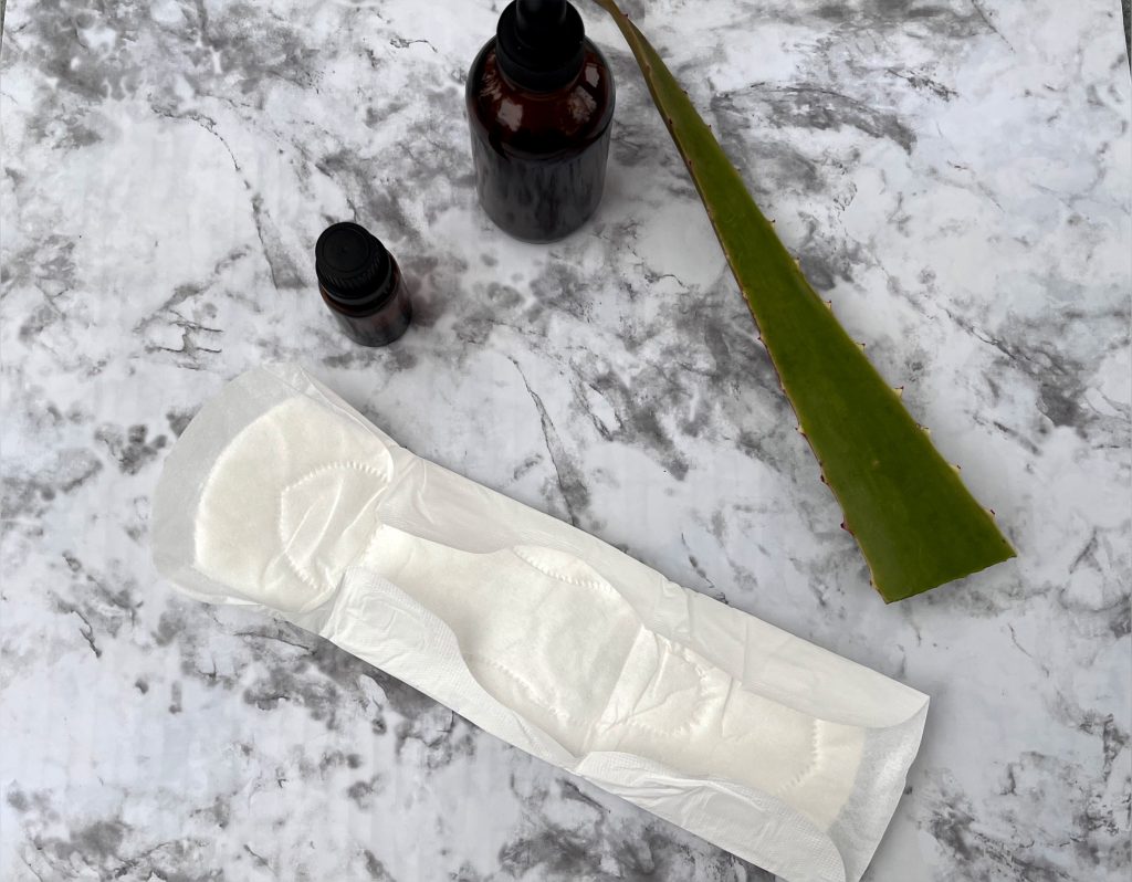 pad, essential oil, witch hazel, and aloe vera sitting on a counter together padsicles