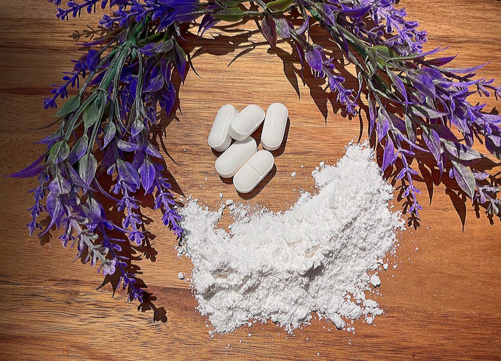 magnesium powder and capsules surrounded by lavender flowers