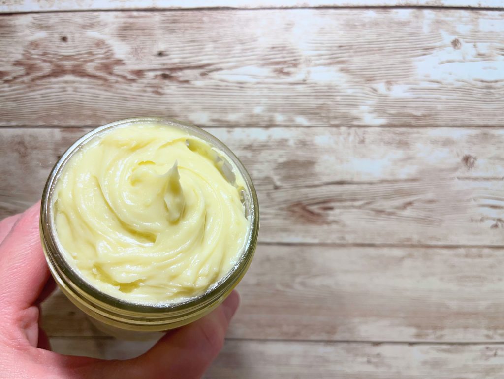 holding up a jar of belly butter